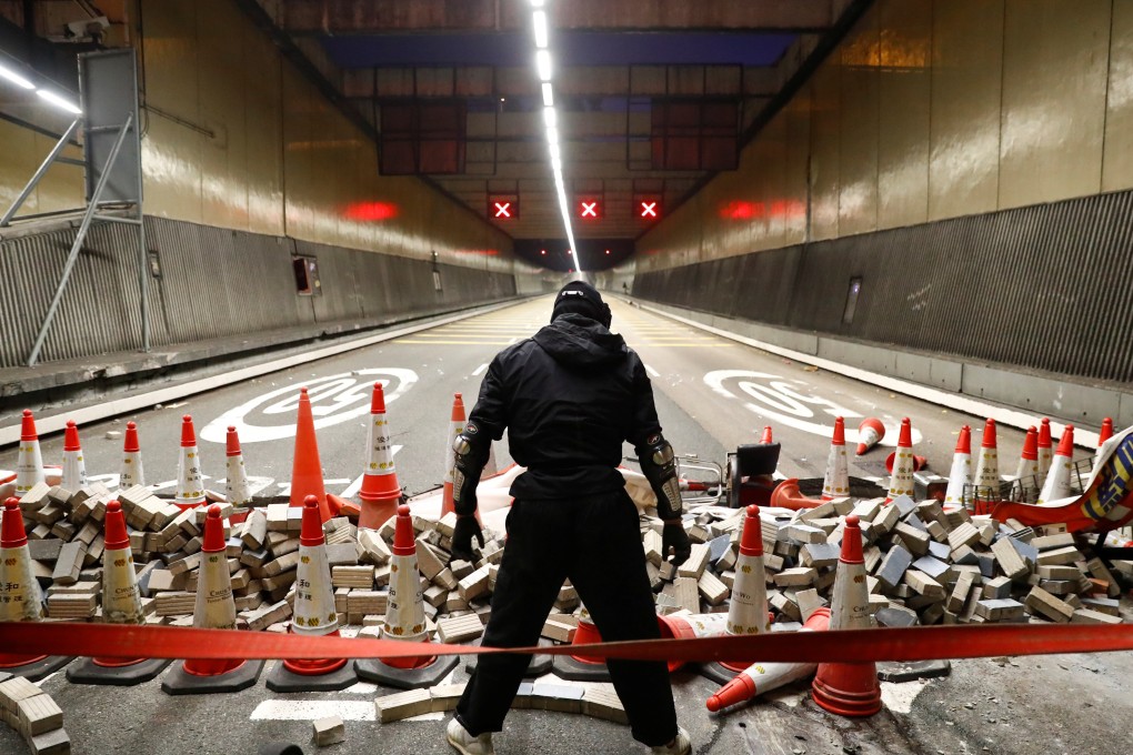 An anti-government protester stands at a blocked lane of the Cross-Harbour Tunnel near Polytechnic University on November 16. Photo: Reuters