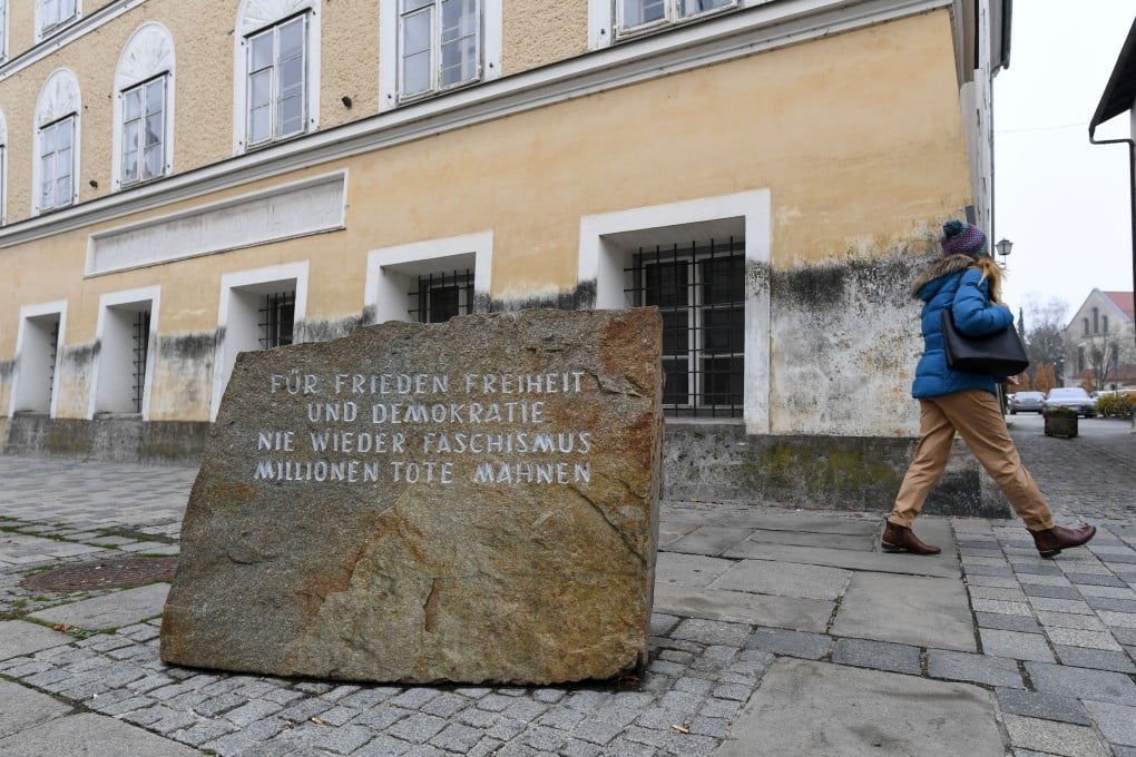 A woman walks past a memorial reading “For peace, liberty and democracy. Never again Fascism” in front the house where Adolf Hitler was born, in Braunau, Austria on Wednesday. Photo: Reuters