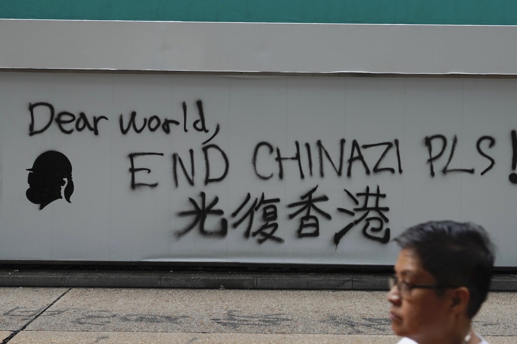 A man walks past a wall spray-painted with an anti-China message on October 7. Photo: AP