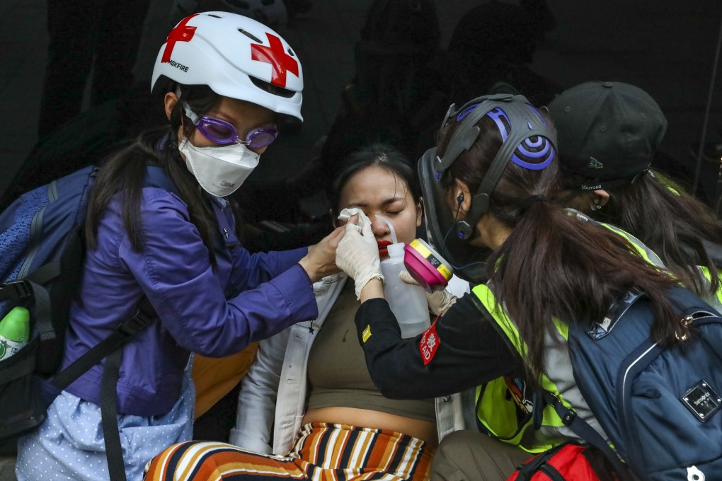 First aiders treat a woman affected by tear gas during anti-government protests in Central, Hong Kong. Photo: K.Y. Cheng