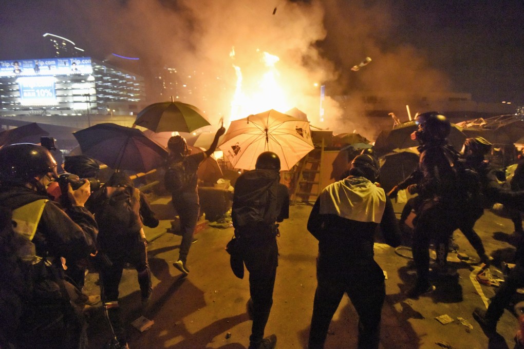Young protesters throw petrol bombs at police outside the Hong Kong Polytechnic University. Photo: Kyodo