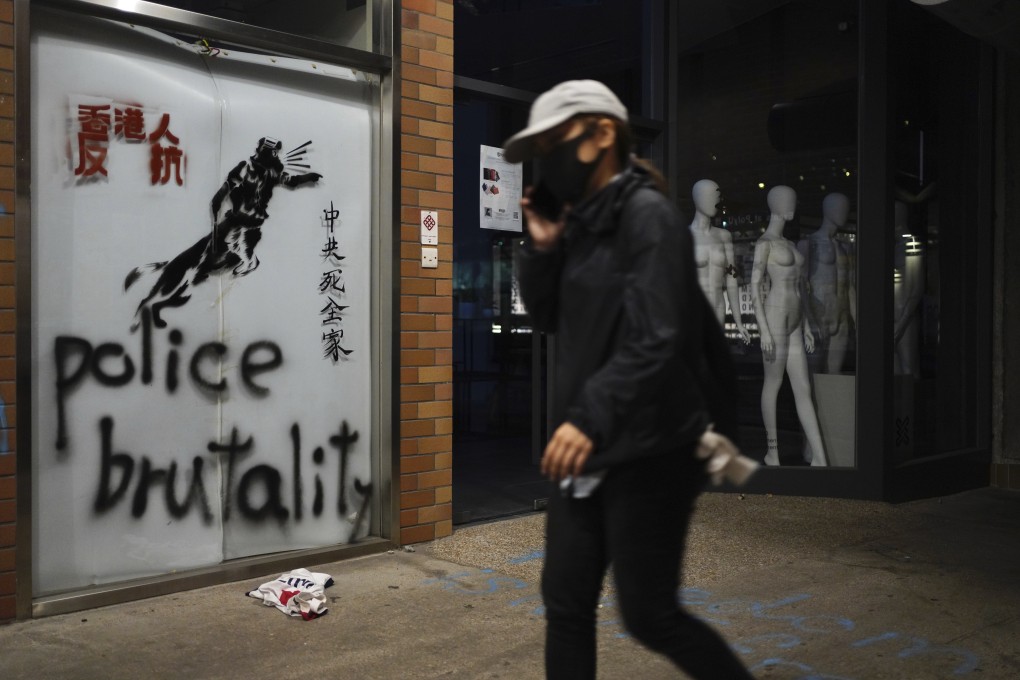 A protester walks past graffiti depicting a police officer as a dog, and with slogans including “Hongkongers resist” and “Death to all Chinese Communist families”, at Polytechnic University in Hung Hom on November 20. Photo: AP