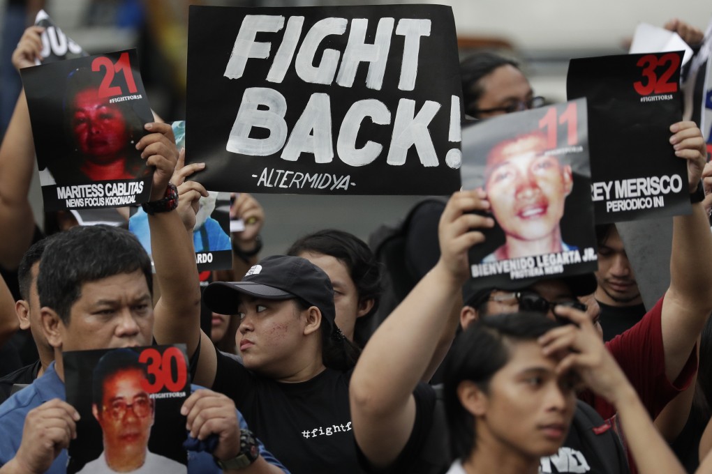 Campaigners in Manila hold pictures of victims as they mark the 10th anniversary of the massacre of 58 people, on November 23, 2019. Photo: AP