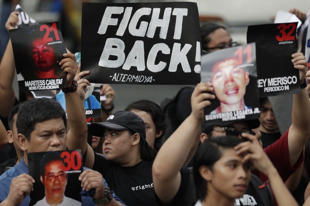 Campaigners in Manila hold pictures of victims as they mark the 10th anniversary of the massacre of 58 people, on November 23, 2019. Photo: AP