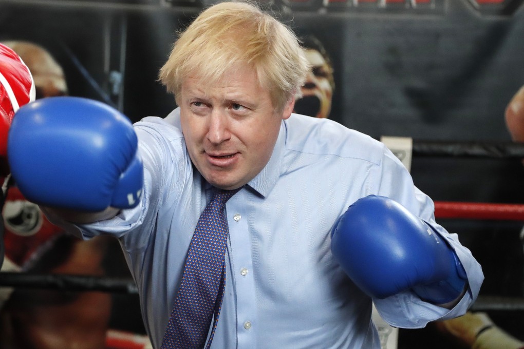 Britain's Prime Minister Boris Johnson works out with trainer Steve Egan during am election campaign stop. Photo: AP