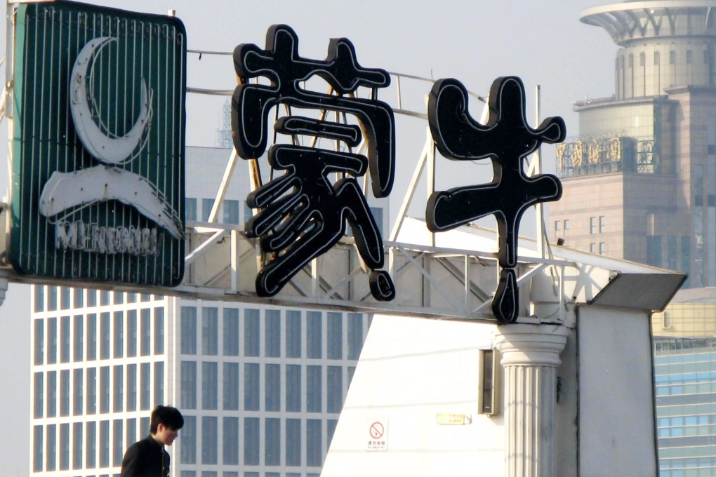 A man walks under a Mengniu billboard on a sightseeing boat in Shanghai in April 2011. Photo: Imaginechina