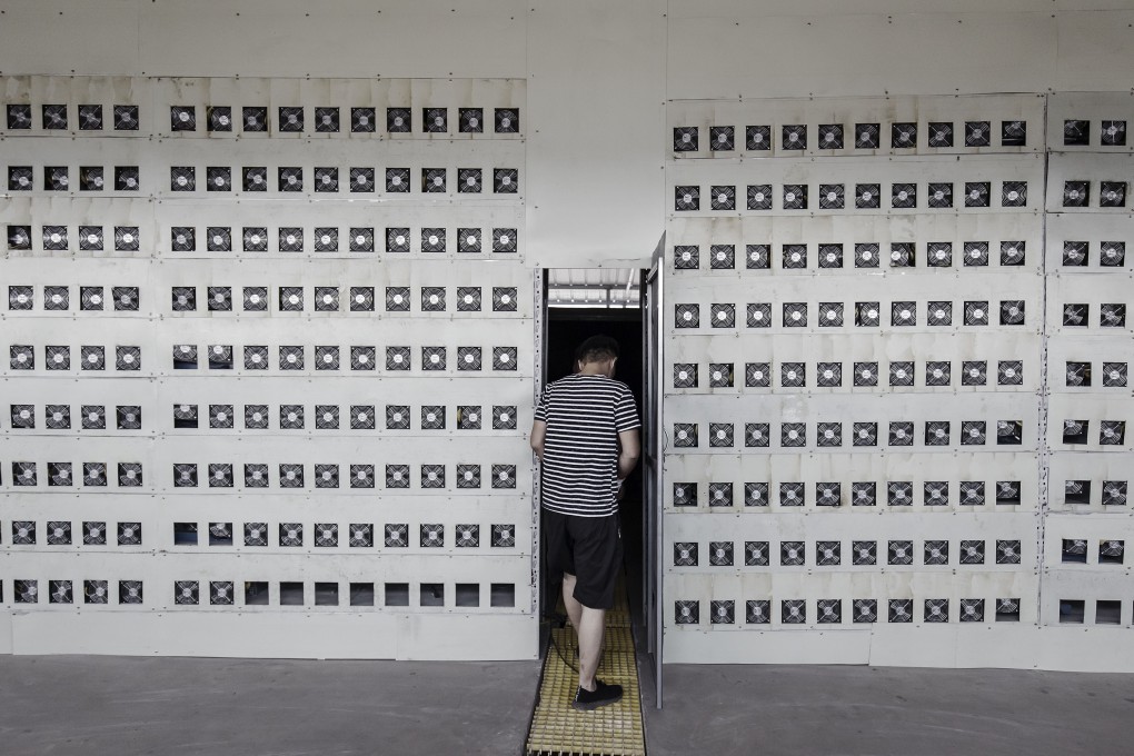 Technicians exit a cooling chamber adjacent to a wall of bitcoin mining machines at a mining facility in Inner Mongolia. Photo: Bloomberg