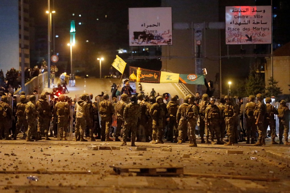 Soldiers form a barrier to separate Hezbollah supporters from anti-government demonstrators in Beirut on Monday. Photo: Reuters