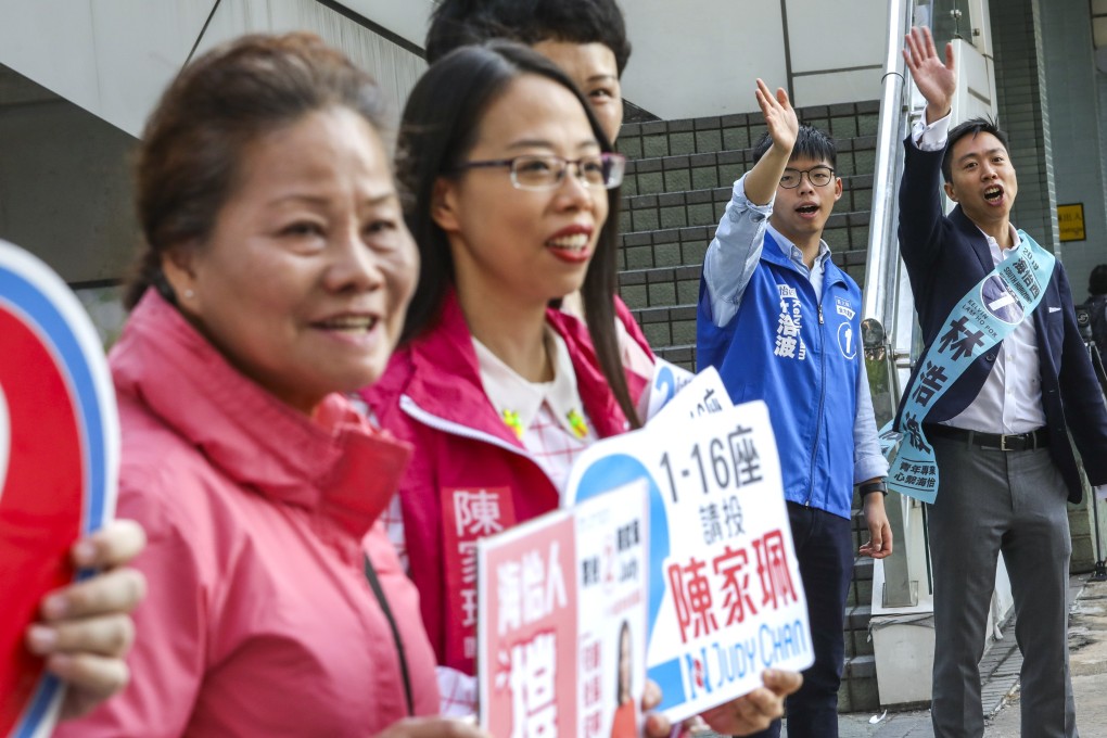 Joshua Wong (second right) and Kelvin Lam arrive at the South Horizons polling station for the district council elections. Photo: May Tse