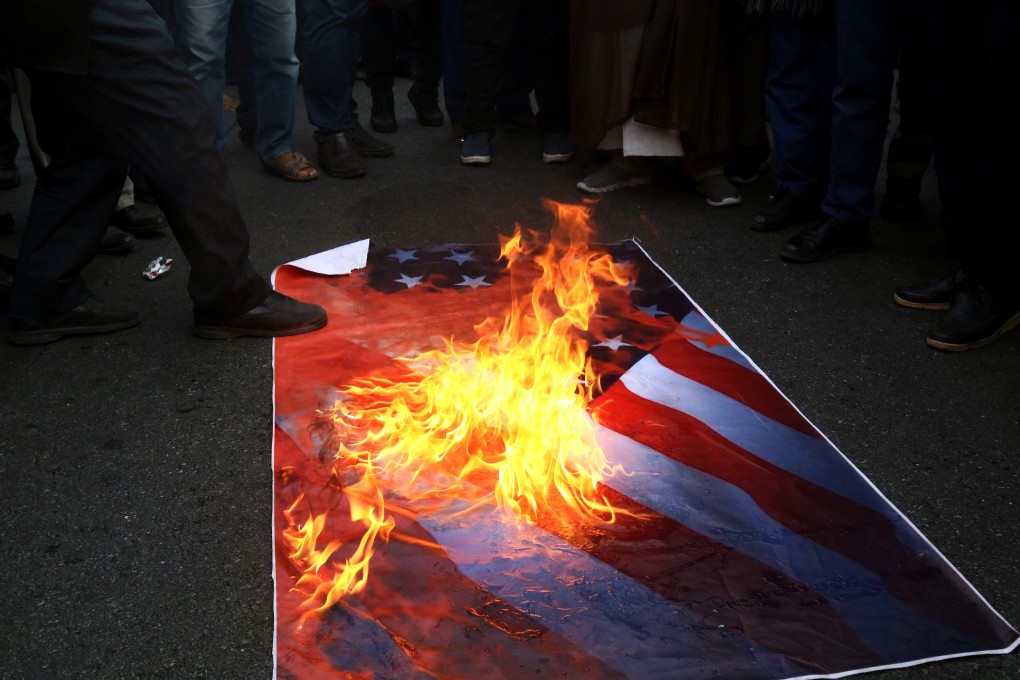 Iranian pro-government protesters burn an US flag as they attend a demonstration in Tehran, Iran. Photo: Reuters