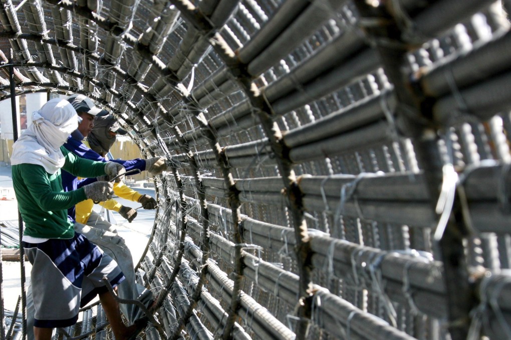 Filipino labourers prepare steel reinforcement bars for the construction of a highway flyover in Manila. Photo: EPA
