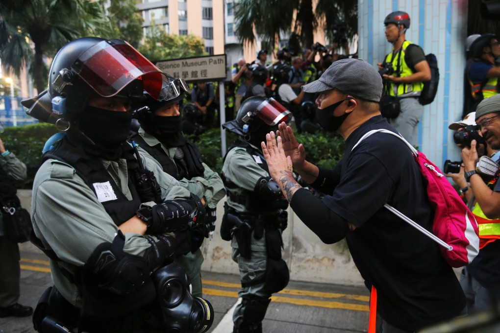 A pro-democracy advocate confronts riot police in Hong Kong on Sunday, when pan-democrat candidates scored landslide victories in district council elections. Photo: EPA-EFE