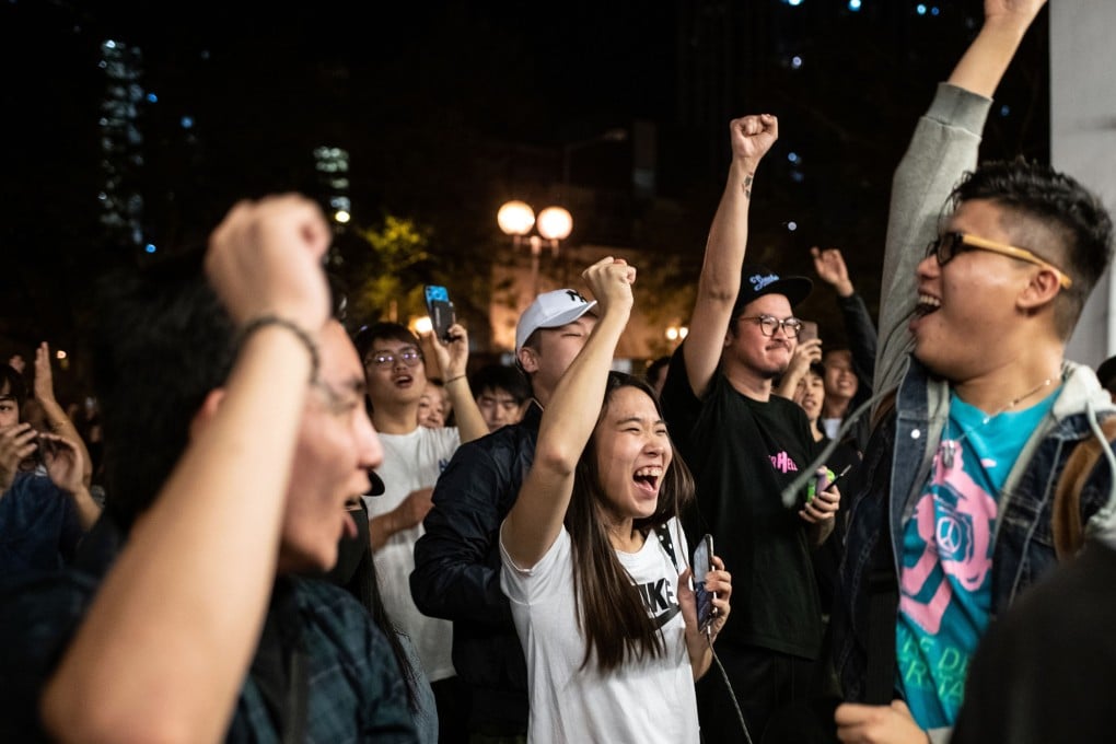 Pro-democracy supporters celebrate the defeat of Junius Ho Kwan-yiu, one of the most high-profile losers in Sunday’s vote. Photo: AFP
