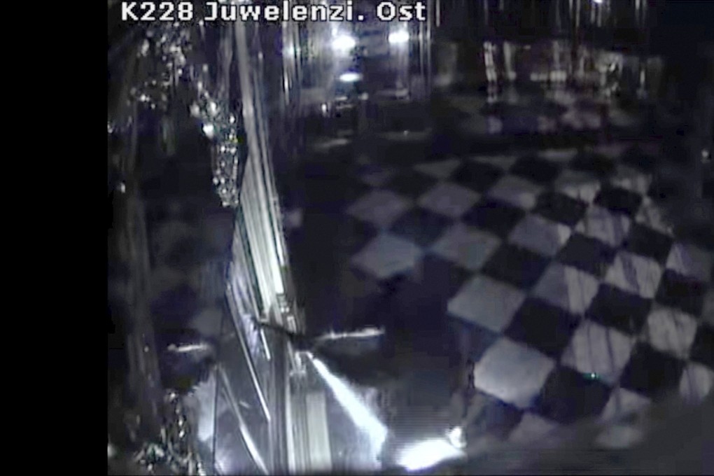 An image take from CCTV footage shows one of the thieves destroying display cases with jewels inside the Green Vault in Dresden, Germany, early Monday. Photo: DPA