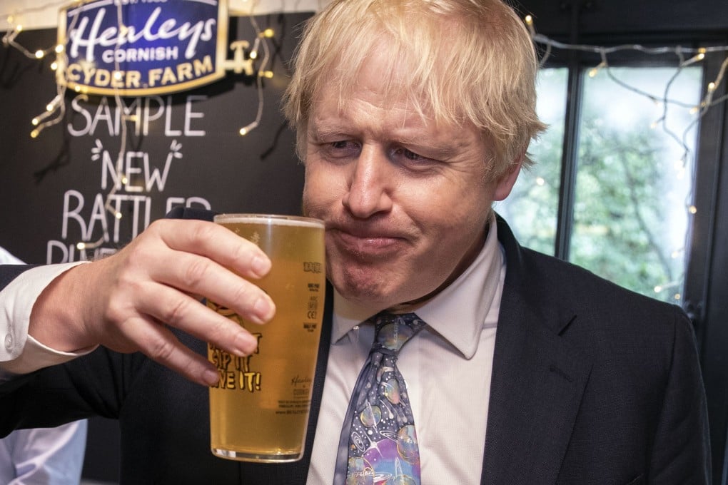 Britain's Prime Minister Boris Johnson takes a sip of cider as he visits Healey's Cornish Cyder Farm in Callestick, Cornwall on Wednesday. Photo: AFP