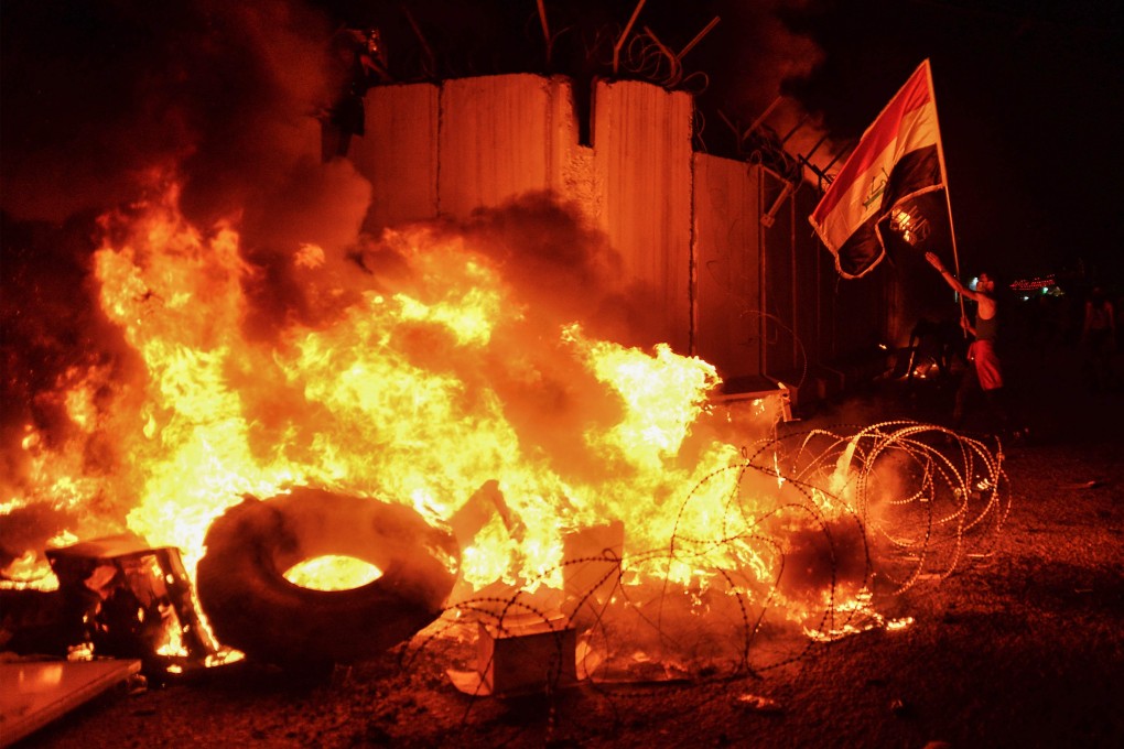 Iraqi demonstrators gather as flames start consuming Iran's consulate in the southern Iraqi city of Najaf on Wednesday. Photo: AFP