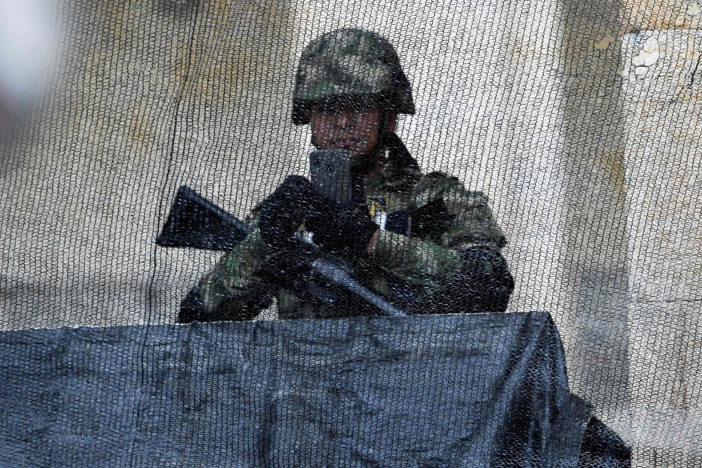 A Colombian soldier takes a photo while guarding the National Congress during a protest against the government in Bogota. Photo: AFP
