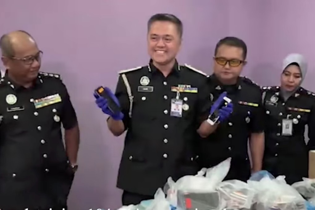 Malaysian officials are seen after 104 Chinese nationals were detained in the city of Kota Kinabalu over their alleged involvement in an online scam syndicate. Photo: Daily Express TV