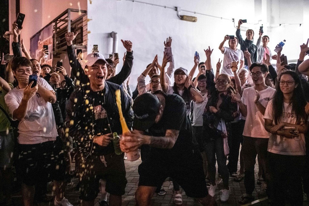 Supporters of pro-democracy candidates celebrate with champagne in Tuen Mun on November 25, as results of the previous day’s Hong Kong district council elections come in. Photo: AFP