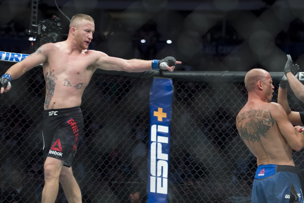 Justin Gaethje walks off as the referee checks on Donald Cerrone after stopping their fight. Photo: AP