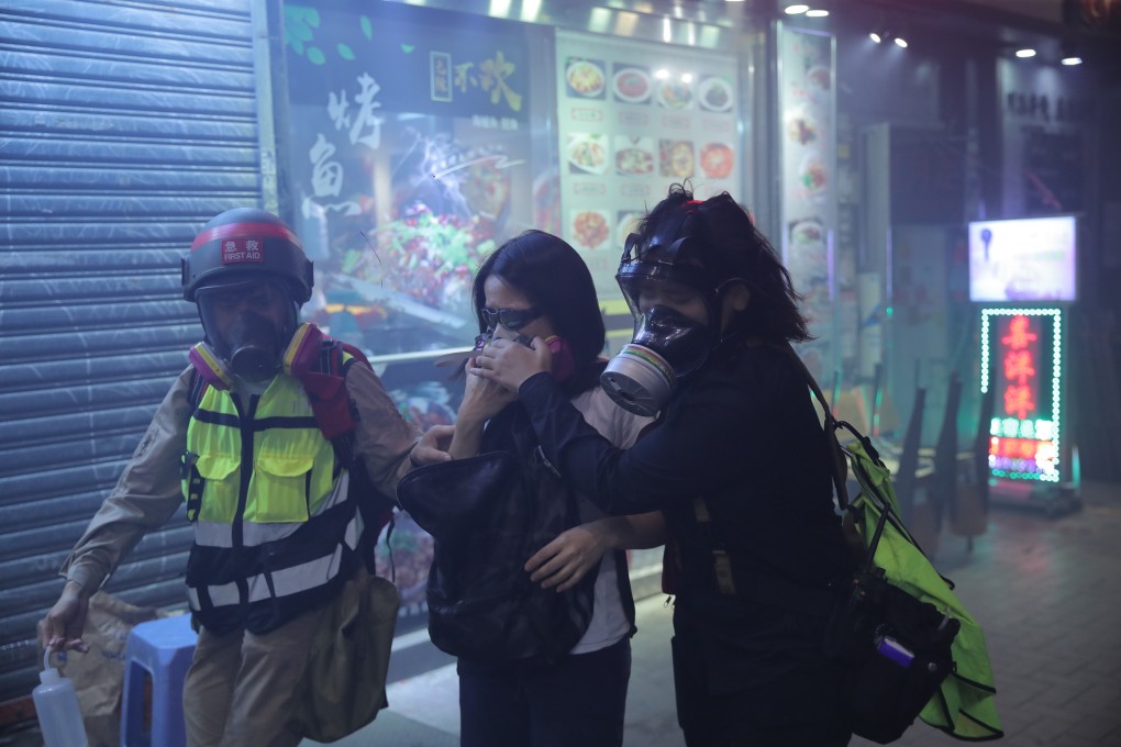 A woman suffers from the immediate effects of tear gas, but what impact can the chemical irritant have in the longer term? Photo: AP