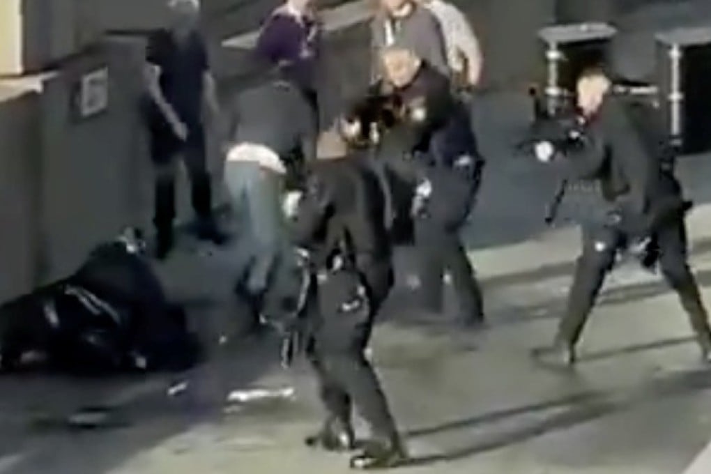 Police officers aim their weapons at Usman Khan. Photo: Reuters