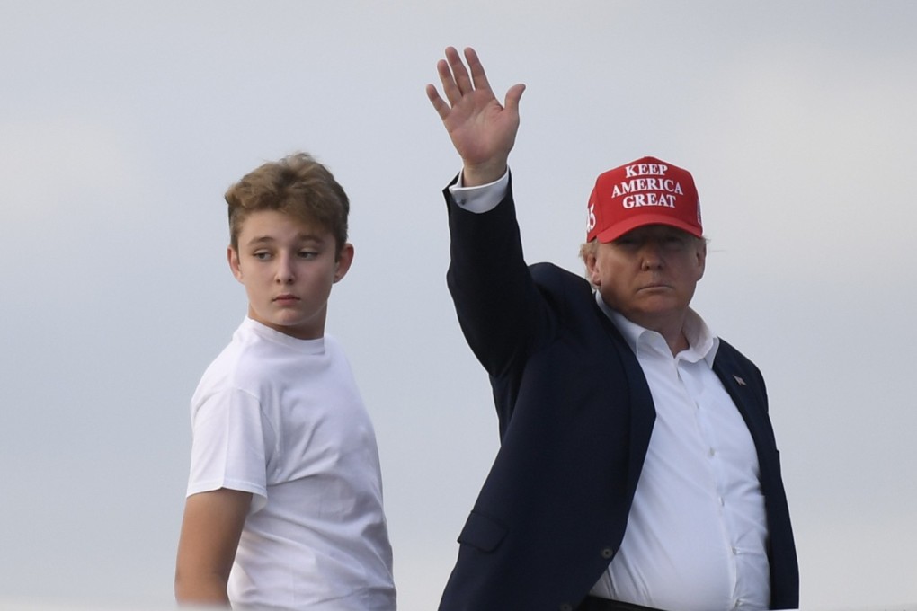 President Donald Trump, standing with his son Barron, waves from the top of the steps of Air Force One. Photo: AP Photo