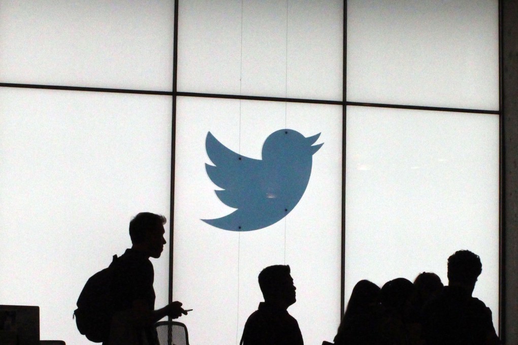 Employees walk past a lighted Twitter log as they leave the company's headquarters in San Francisco. Photo: Agence France-Presse