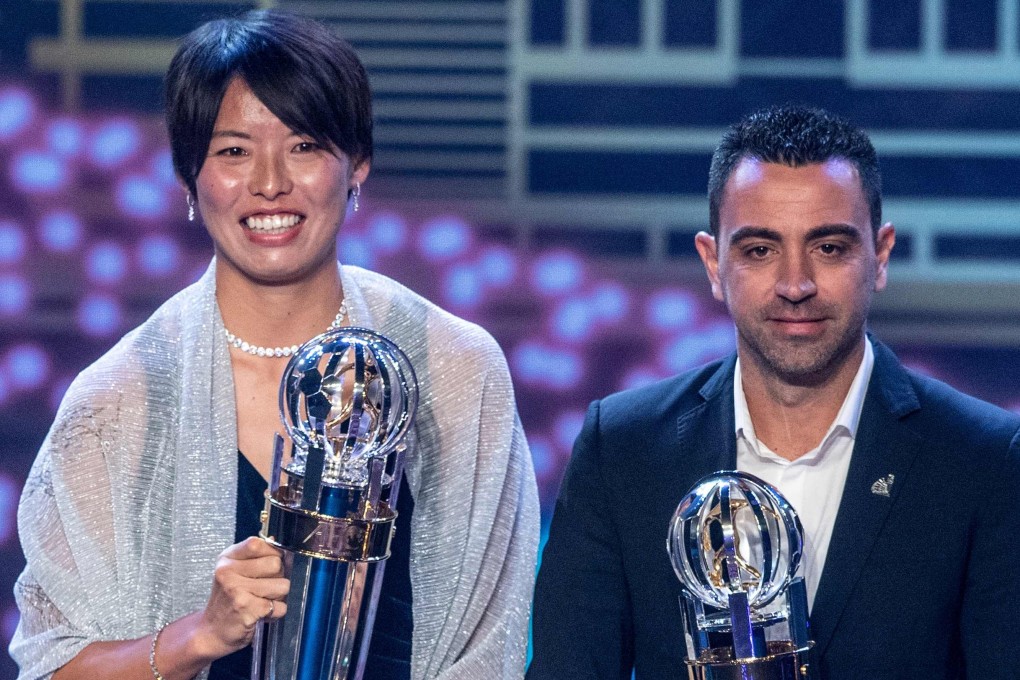 Japan and Olympique Lyonnais star Saki Kumagai (left) wins AFC women's player of the year and poses with Al Sadd SC coach Xavi Hernandez, who receives the men's player of the year award on behalf of Akram Afif. Photo: AFP