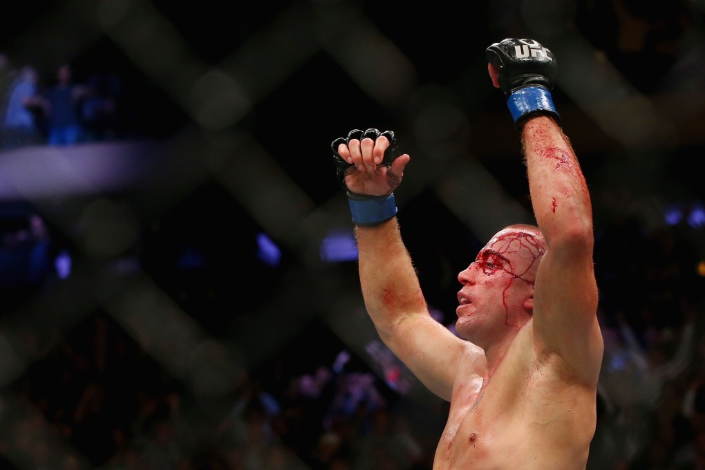 Georges St-Pierre celebrates his victory over Michael Bisping at UFC 217. Photo: AFP