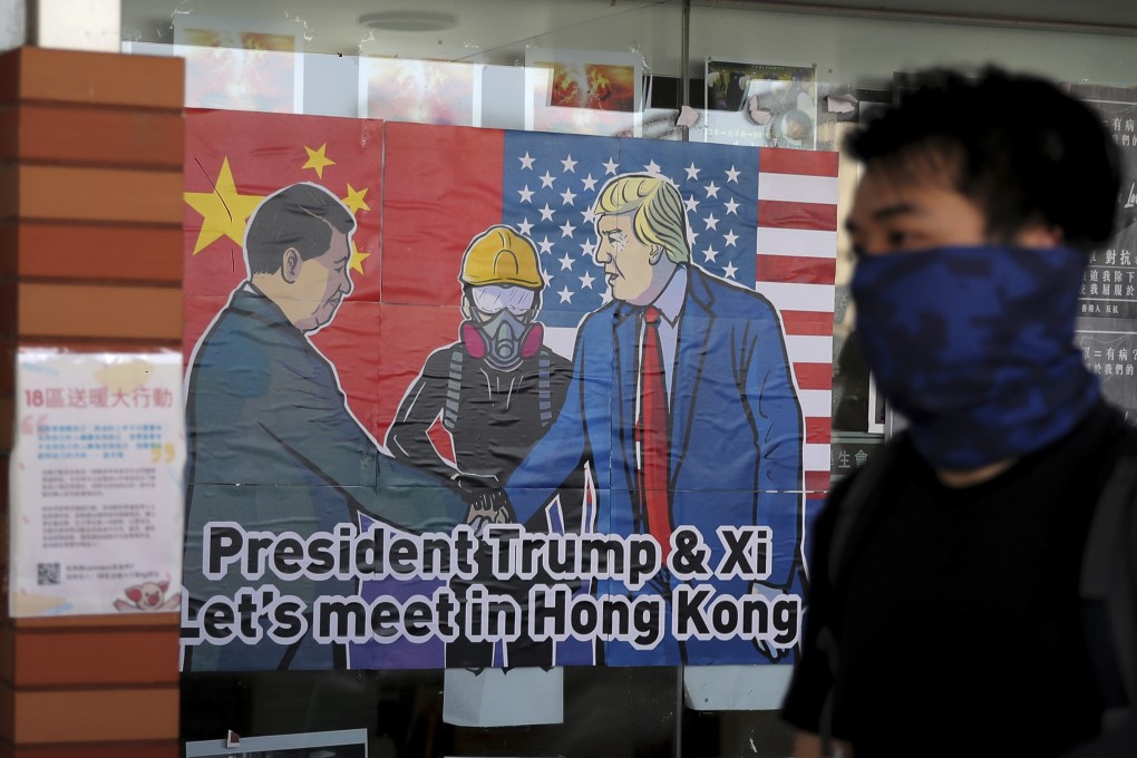 A protester walks past a poster featuring Chinese President Xi Jinping and US President Donald Trump at the University of Hong Kong campus in Pok Fu Lam on November 6. Photo: AP
