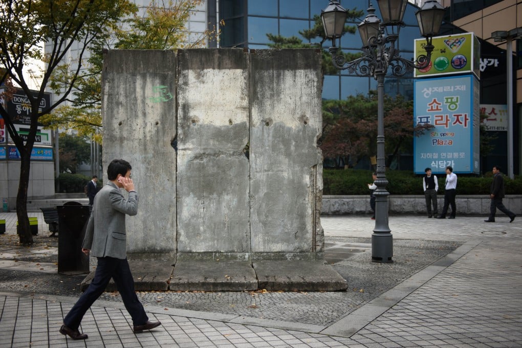 A man walks past a section of the Berlin Wall displayed at ‘Berlin Plaza’ in central Seoul. Photo: AFP