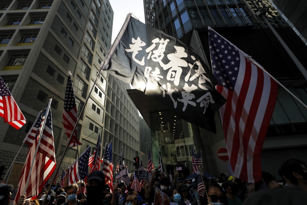 Protesters wave US flags and a banner that reads “Liberate Hong Kong, the Revolution of Our Times” during a rally in Hong Kong on December 1. Photo: AP