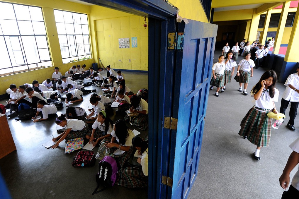 Filipino students, without chairs and desks, at a high school in Manila. Photo: AFP
