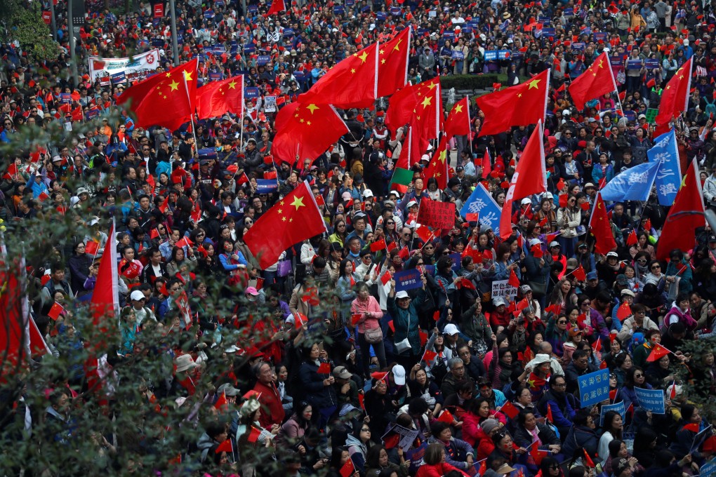 Pro-Beijing supporters wave Chinese national flags at the rally in Harbour Road Garden. Photo: Reuters