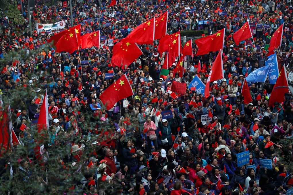 Pro-Beijing supporters wave Chinese national flags at the rally in Harbour Road Garden. Photo: Reuters