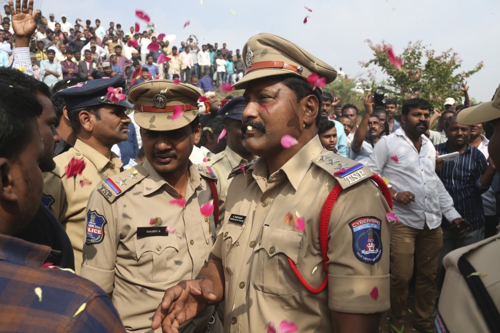 People throw flower petals on the Indian policemen guarding the area where rape accused were shot. Photo: AP