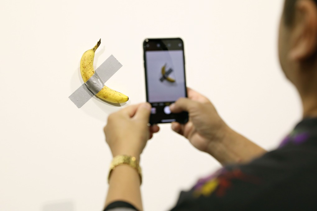 A visitor takes a photo of Maurizio Cattelan's “Comedian” at Art Basel Miami on Friday. Photo: AFP