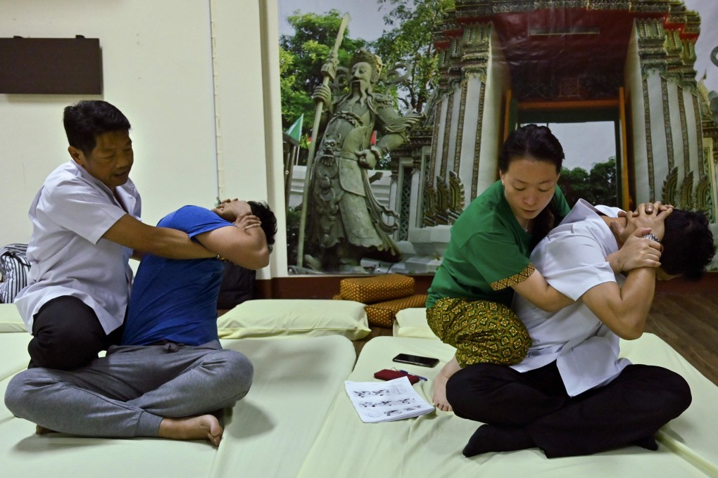 A Thai massage instructor (left) trains his student from Hong Kong at the Wat Po Thai traditional massage school in Bangkok. Photo: AFP
