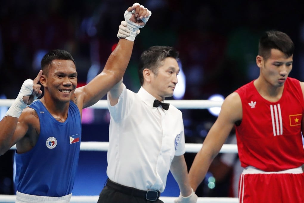 Eumir Marcial (left) has his arm raised after a first-round knockout in the men’s boxing middleweight final in Manila, the Philippines. Photo: EPA