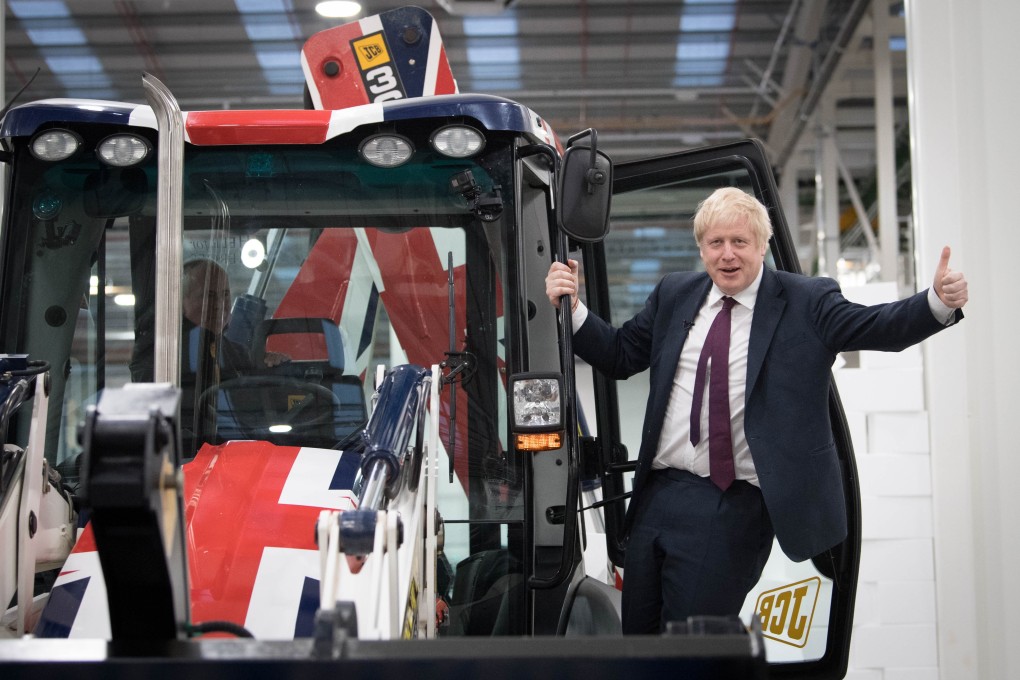 UK Prime Minister Boris Johnson emerges from the cab of the ‘Brexit’ digger during a campaign stop in Staffordshire. Photo: DPA