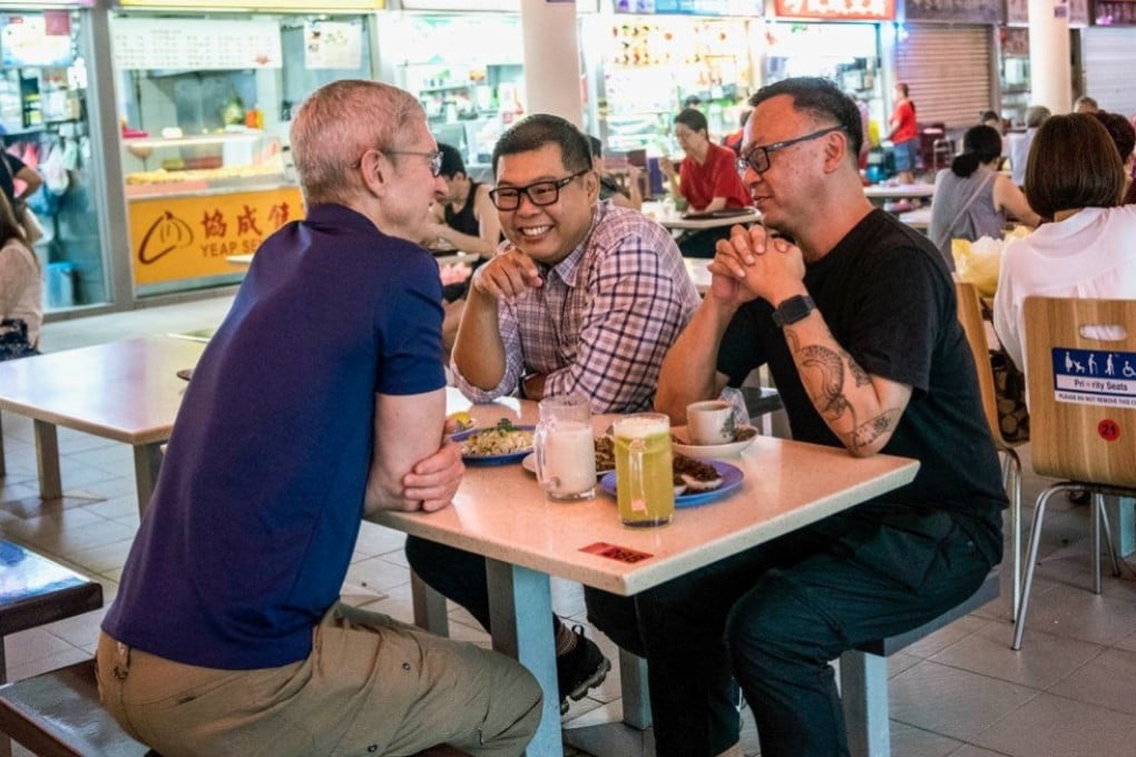 Apple CEO Tim Cook speaks with photographers Darren Soh and Aik Beng Chia at a hawker centre in Singapore. Photo: Twitter