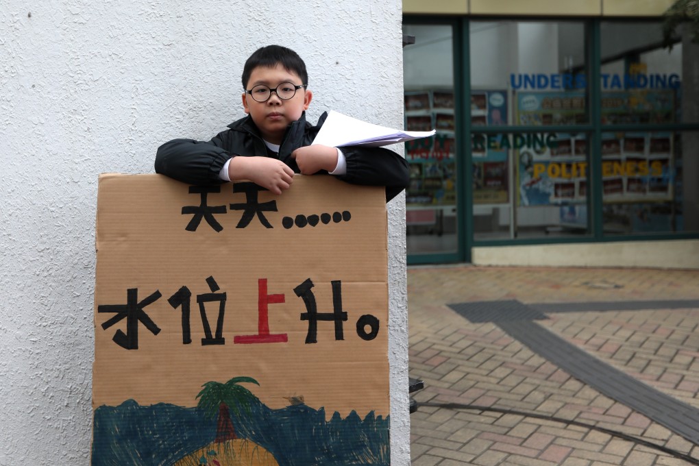 Lance Lau Hin-yi protests outside his school in Hong Kong before class last Friday. Only 10 years old, he is passionate about saving the environment. Photo: Xiaomei Chen