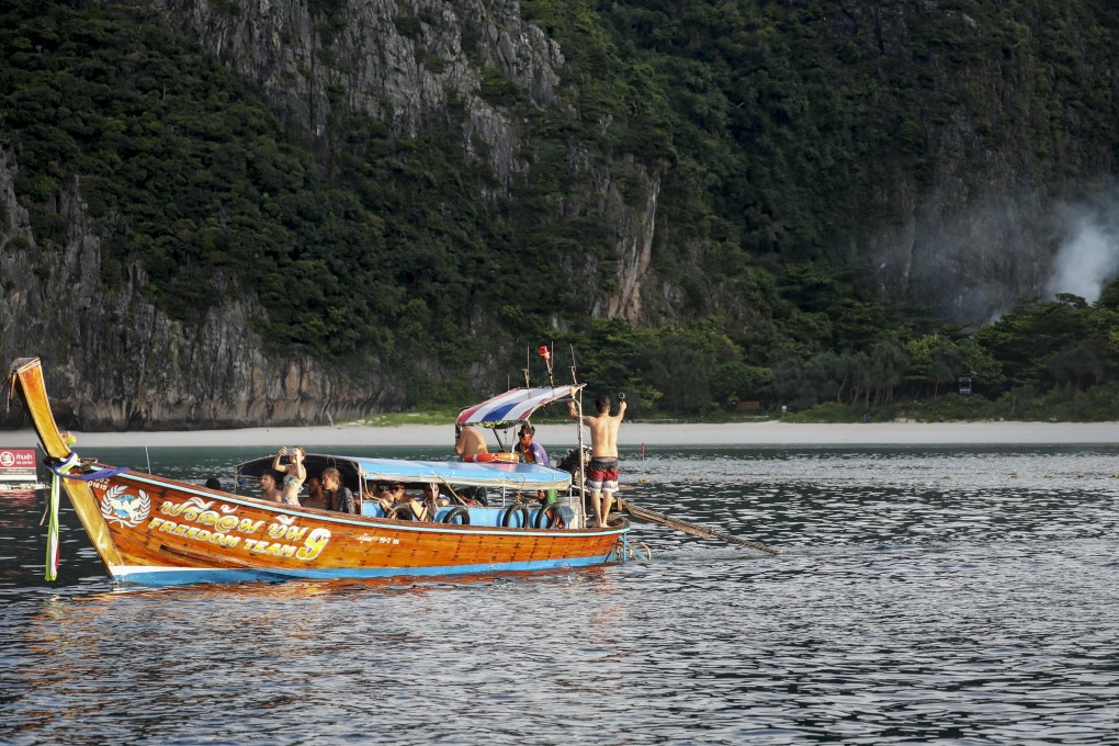 Tourists on a long-tail boat look longingly towards Maya Bay, Ko Phi Phi Lee, Thailand. Photo: James Wendlinger