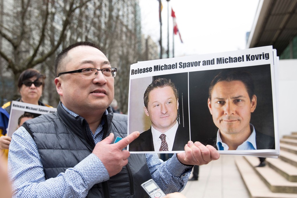 Louis Huang of Vancouver Freedom and Democracy for China holds photos of Canadians Michael Spavor and Michael Kovrig, who are being detained by China. Photo: AFP