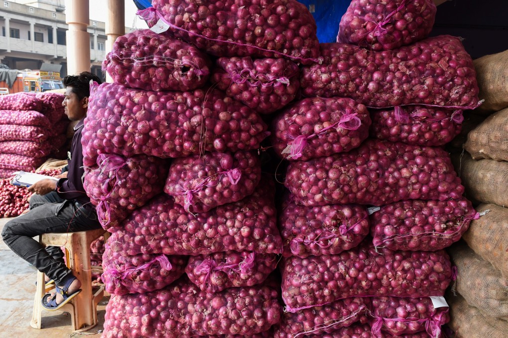 A trader selling onions waits for customers at a market in Ahmedabad, India. Photo: AFP