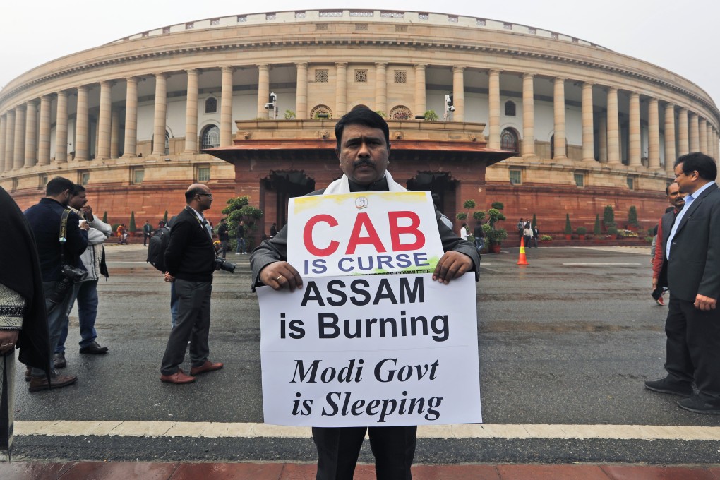 An Indian lawmaker holds a banner in protest against the Citizenship Amendment Bill at the Parliament House in New Delhi on December 13, 2019. Indian authorities have relaxed curfew in violence-hit parts of the northeastern state of Assam but shut schools until next week as protests continue against a new law that would grant citizenship to non-Muslims who migrated from neighbouring countries. Photo: AP