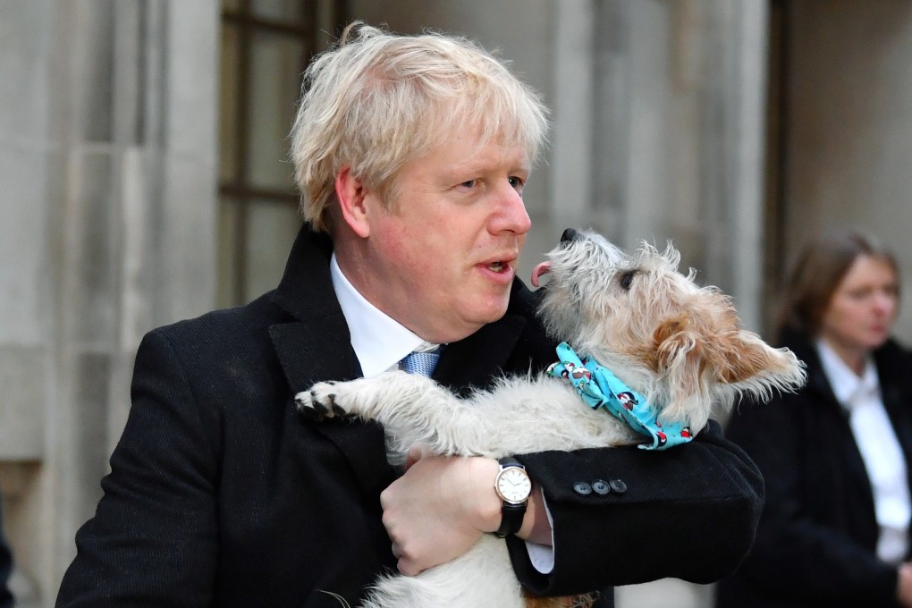 Britain's Prime Minister Boris Johnson holds his dog as he leaves a polling station in London. Photo: Reuters