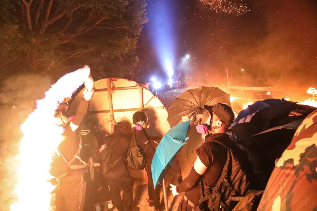 A frontline protester hurls a petrol bomb at riot police during clashes at Chinese University. Photo: Felix Wong