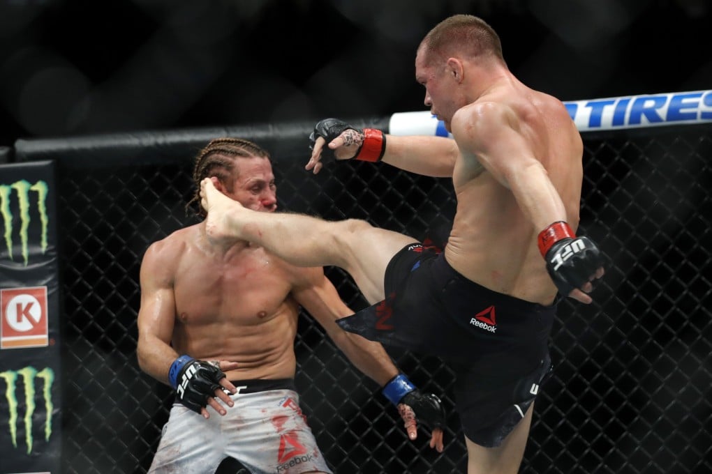 Petr Yan lands a kick on Urijah Faber that sends him to the canvas in the third round of their bantamweight fight during UFC 245. Photo: AFP